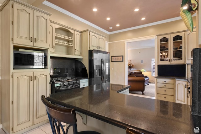 kitchen featuring crown molding, cream cabinets, and stainless steel appliances