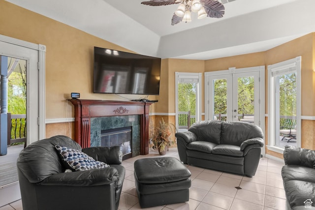 living area featuring tile patterned floors, ceiling fan, and a wealth of natural light