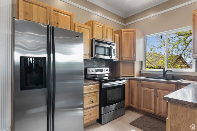 kitchen featuring ornamental molding, dark countertops, tasteful backsplash, a sink, and stainless steel appliances