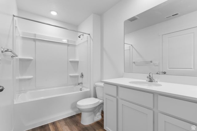 full bath featuring visible vents, vanity, wood finished floors, toilet, and washtub / shower combination