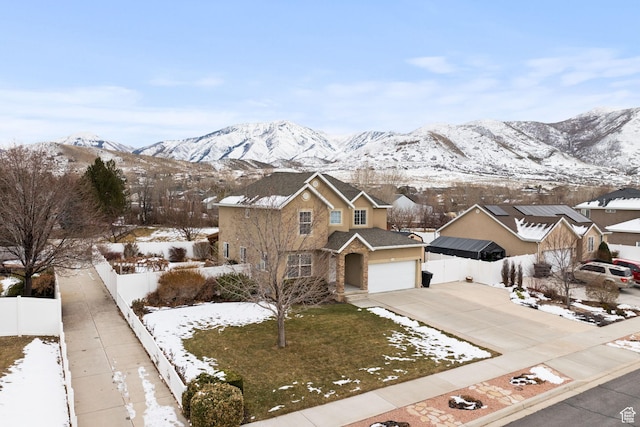 view of front of home with a mountain view, fence, and driveway