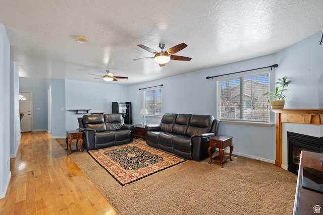 living area with a textured ceiling, ceiling fan, and a wealth of natural light