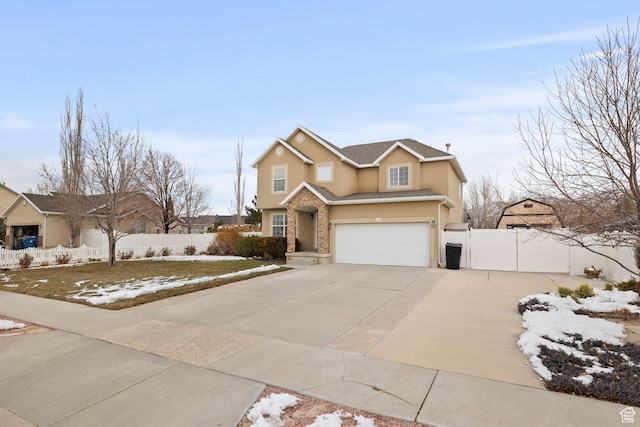 traditional-style home featuring fence, an attached garage, stucco siding, a gate, and concrete driveway