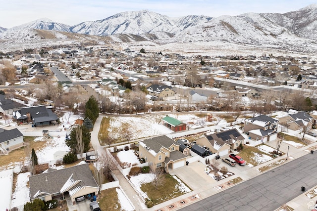 snowy aerial view featuring a residential view and a mountain view