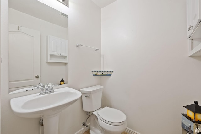 bathroom featuring baseboards and toilet