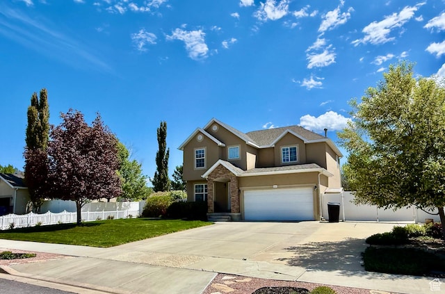 traditional home featuring a garage, a front lawn, fence, stucco siding, and concrete driveway