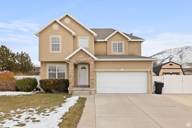 traditional home featuring fence, an attached garage, stucco siding, a mountain view, and concrete driveway