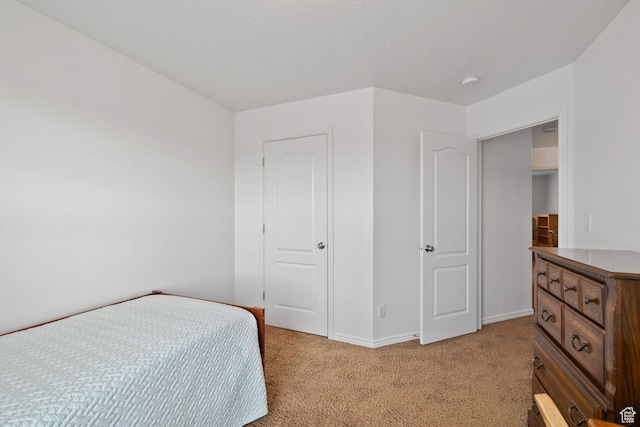 bedroom with baseboards and light carpet