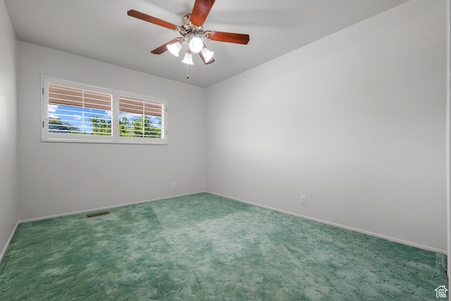 empty room with baseboards, carpet flooring, ceiling fan, and visible vents