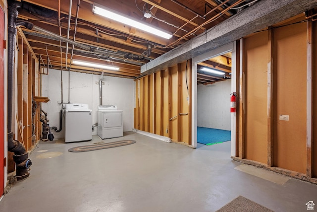 unfinished below grade area with washing machine and clothes dryer