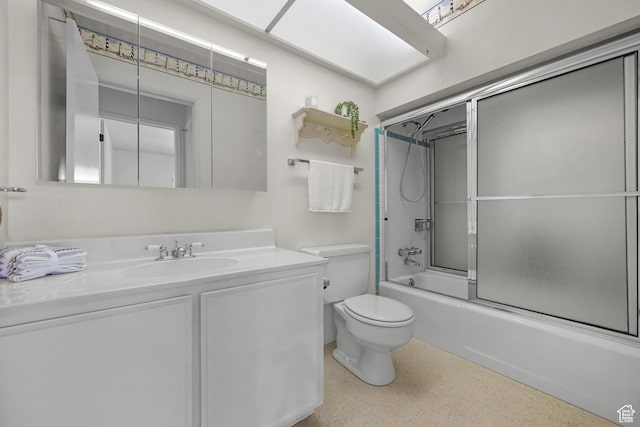 bathroom with vanity, enclosed tub / shower combo, toilet, and speckled floor