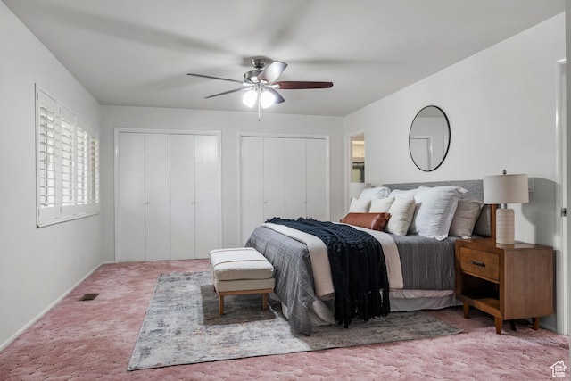 bedroom with multiple closets, carpet, a ceiling fan, baseboards, and visible vents