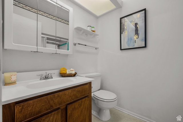 half bath with vanity, baseboards, and toilet