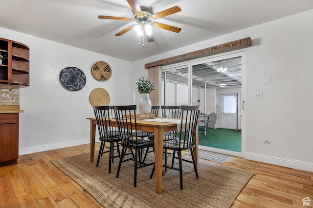 dining area with light wood-style floors, baseboards, and a ceiling fan