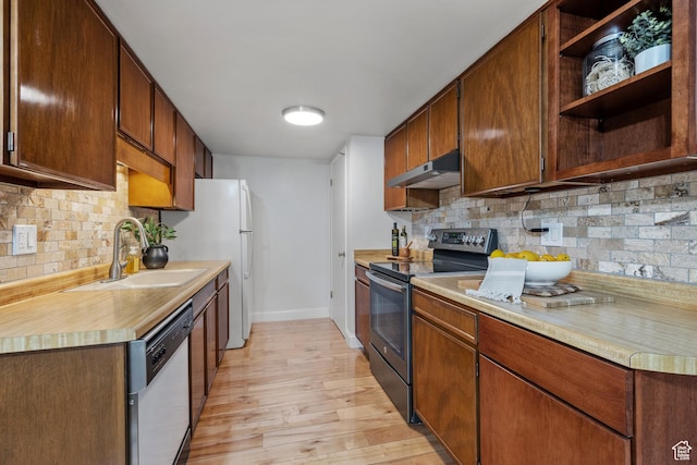 kitchen with a sink, stainless steel range with electric stovetop, baseboards, under cabinet range hood, and dishwashing machine