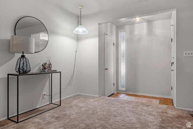 carpeted foyer entrance featuring baseboards
