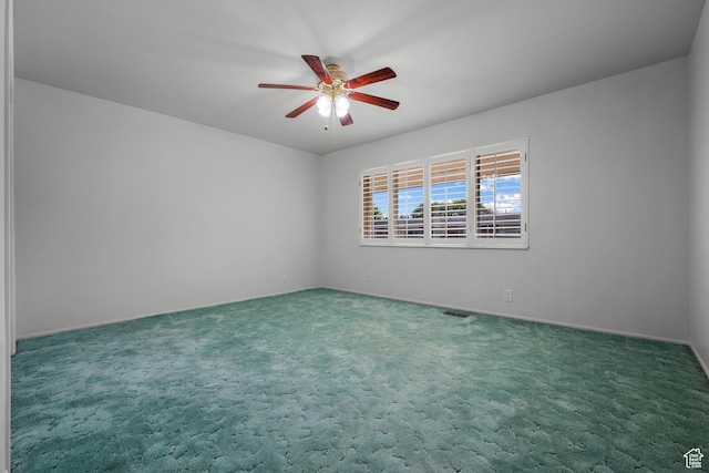 carpeted empty room with ceiling fan and visible vents