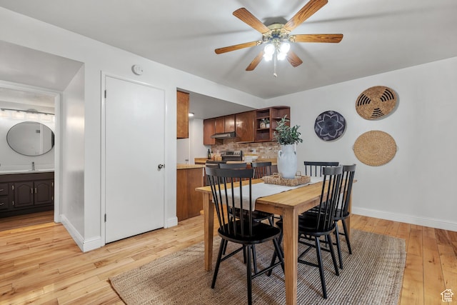 dining space with baseboards, ceiling fan, and light wood-type flooring