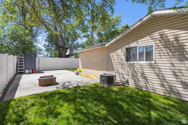 view of yard with a fenced backyard, a patio, an outdoor fire pit, and central AC
