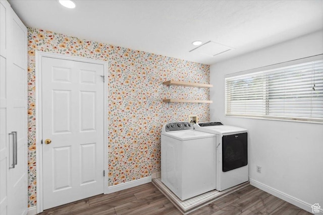 laundry area featuring laundry area, separate washer and dryer, wallpapered walls, baseboards, and wood finished floors