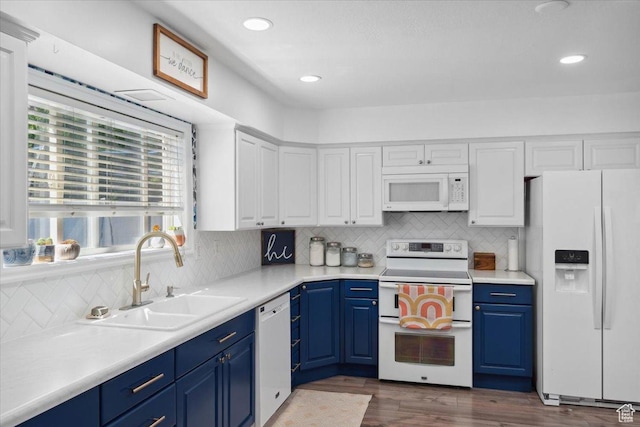 kitchen with a sink, blue cabinets, and white appliances