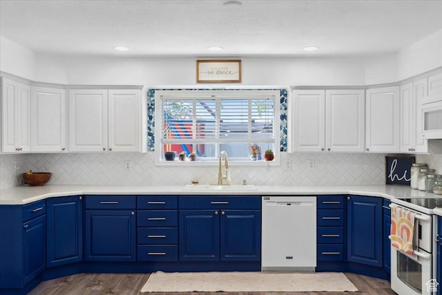 kitchen featuring white appliances, white cabinetry, dark wood finished floors, and a sink