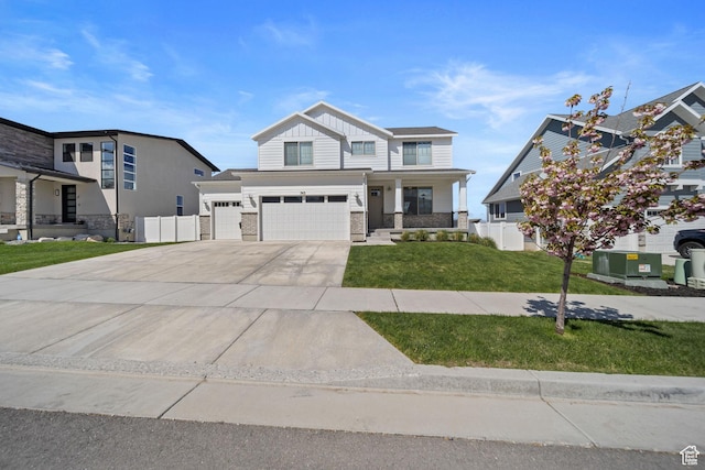 743 N 690 E, Tooele, UT 84074 - view of front facade featuring driveway, a garage, fence, a front lawn, and stone siding
