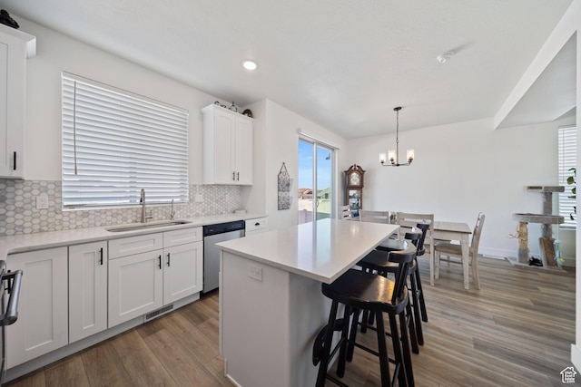 743 N 690 E, Tooele, UT 84074 - kitchen with visible vents, light wood-style floors, a kitchen bar, a sink, and dishwasher