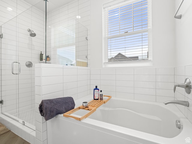 full bathroom featuring a stall shower and a garden tub