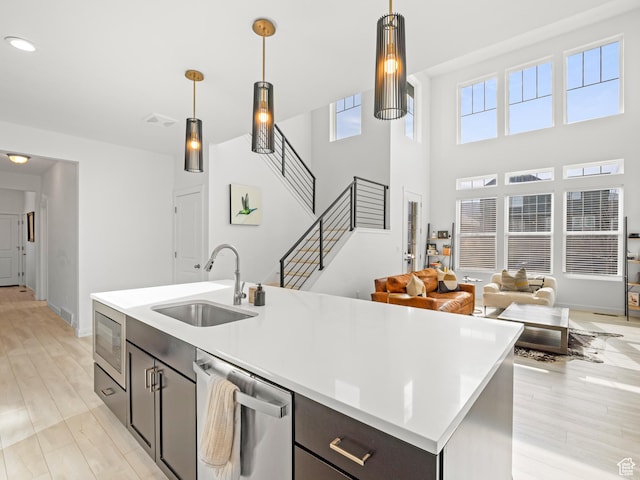 kitchen with light countertops, appliances with stainless steel finishes, a wealth of natural light, and a sink