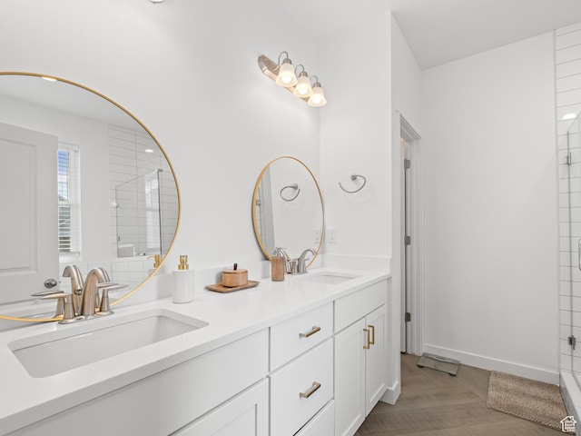 bathroom with double vanity, a sink, a shower, and wood finished floors