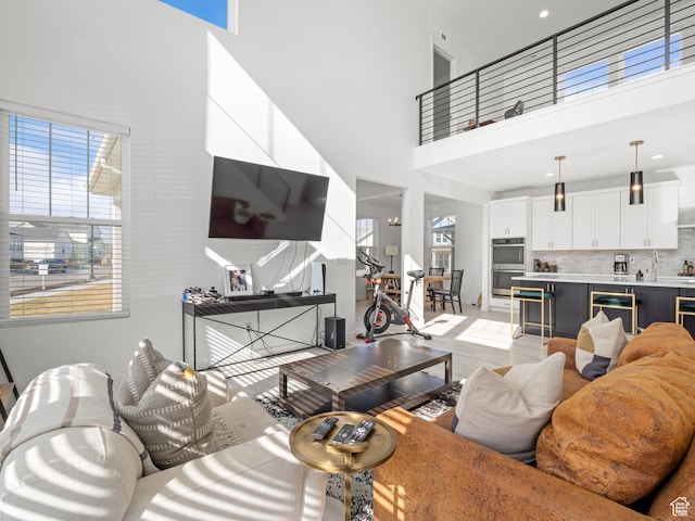 living room featuring light wood-style flooring and a towering ceiling