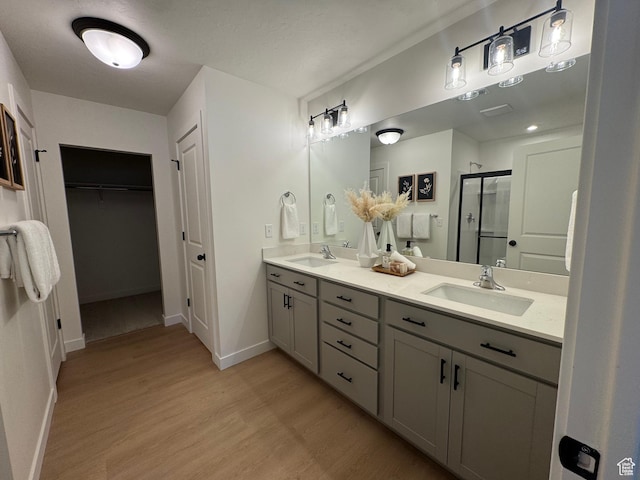 3620 N Stallion St Unit 349, Eagle Mountain, UT 84005 - full bath with a stall shower, wood finished floors, double vanity, baseboards, and a spacious closet