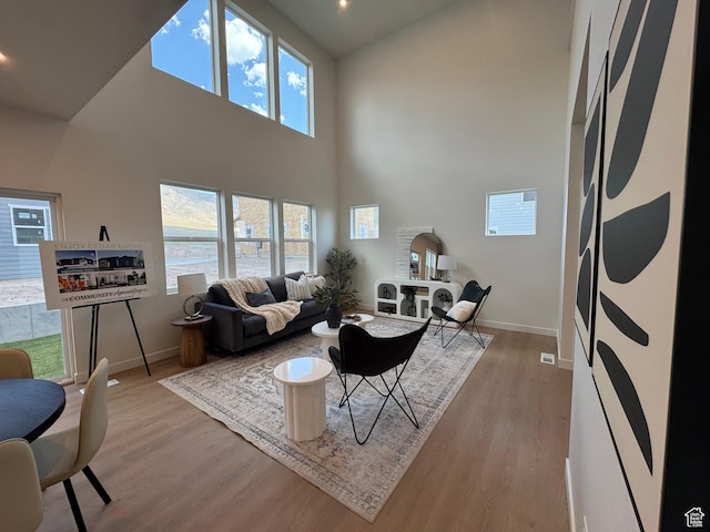 3620 N Stallion St Unit 349, Eagle Mountain, UT 84005 - living room with baseboards, light wood-style floors, a high ceiling, and plenty of natural light