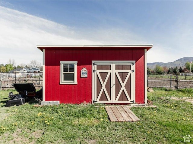 view of shed featuring fence and a mountain view