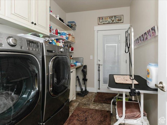 laundry room featuring cabinet space, baseboards, and washer and dryer