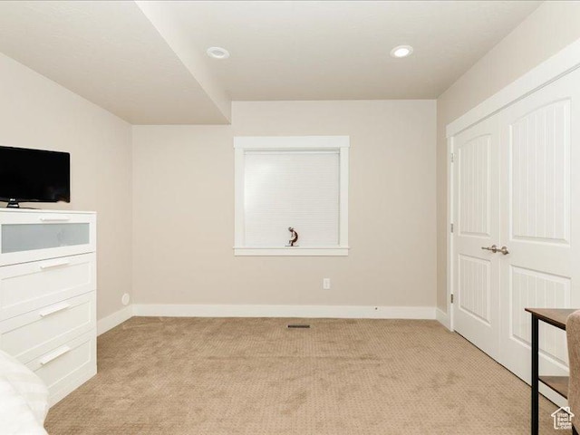 unfurnished bedroom featuring light colored carpet, recessed lighting, baseboards, and visible vents