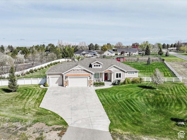 view of front of property featuring fence, a front lawn, and a garage