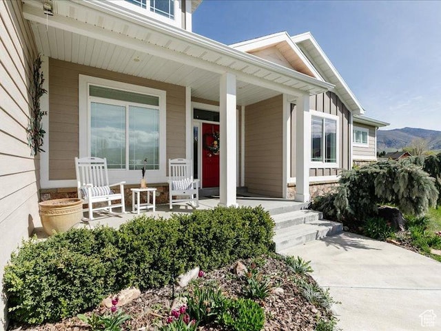 doorway to property featuring a porch and stone siding