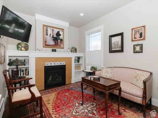 living area with a fireplace with flush hearth, built in features, and recessed lighting