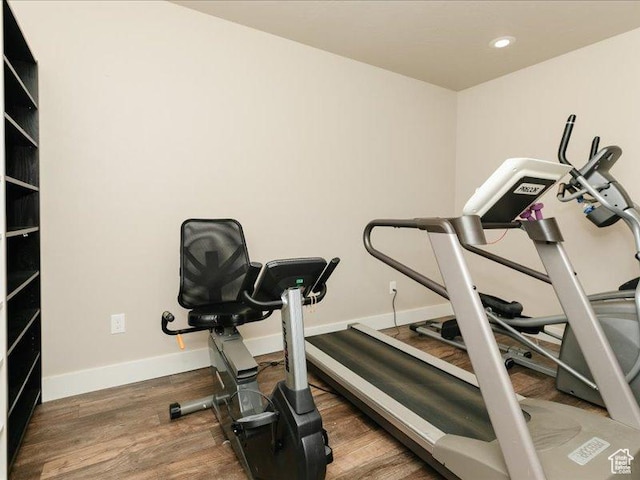 workout room featuring recessed lighting, baseboards, and wood finished floors