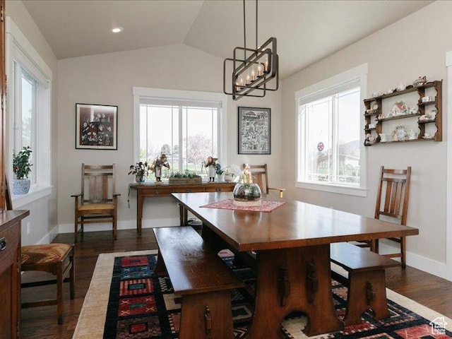 dining room with dark wood-style flooring, lofted ceiling, and a healthy amount of sunlight