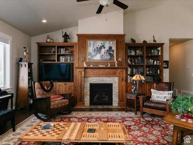 living area featuring ceiling fan, a fireplace, vaulted ceiling, and wood finished floors