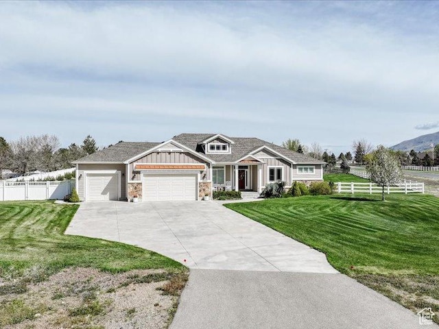 craftsman-style house featuring fence, an attached garage, board and batten siding, a front yard, and concrete driveway