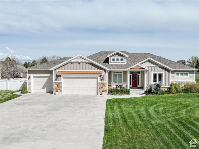 craftsman house featuring covered porch, board and batten siding, an attached garage, and a front lawn