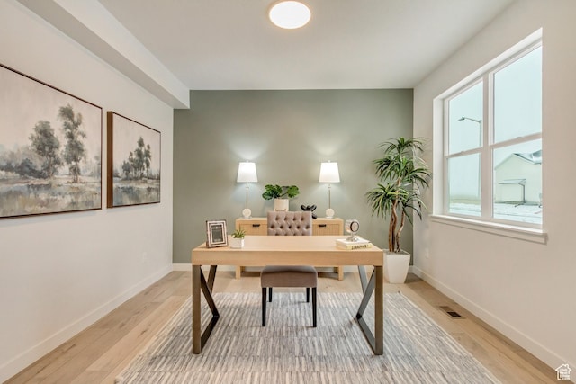 office area with baseboards, visible vents, and light wood-style floors