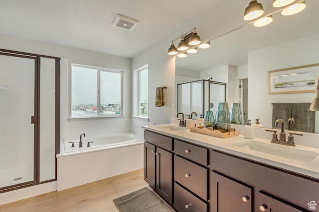 bathroom with a sink, a bath, wood finished floors, and a shower stall