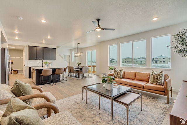 living room featuring ceiling fan, light wood finished floors, and recessed lighting