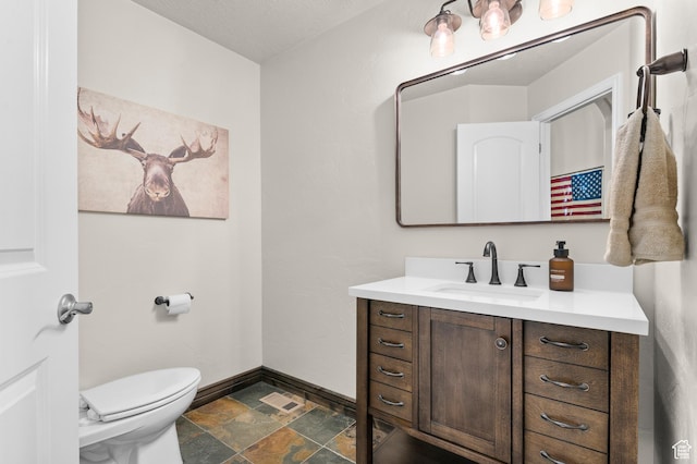 294 W Farmside Dr S, Saratoga Springs, UT 84045 - bathroom with stone finish floors, vanity, toilet, and baseboards