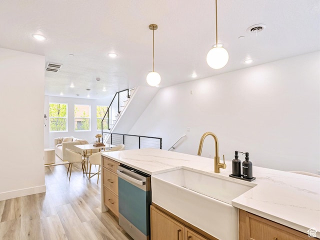 kitchen featuring a sink, light wood-style floors, open floor plan, stainless steel dishwasher, and visible vents